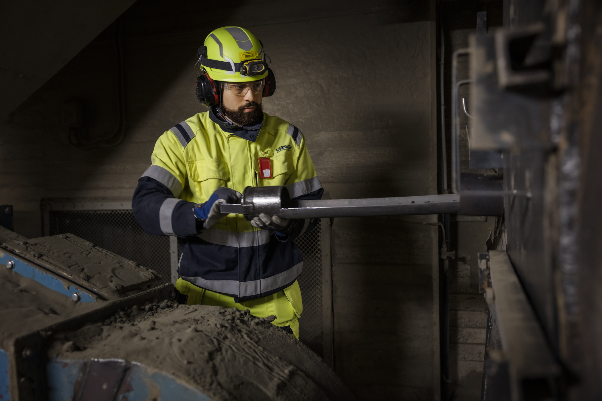 Medarbetare står vid en maskin i cementfabriken i Slite